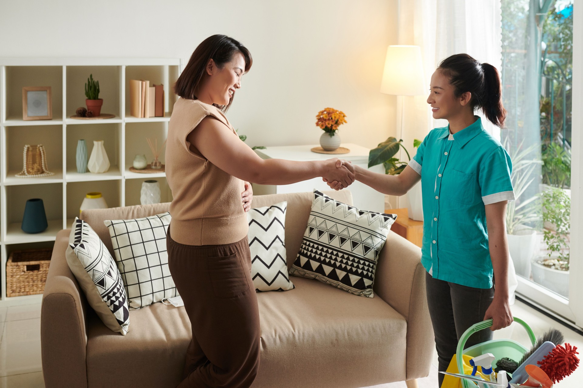 Woman thanking cleaning service worker for her work